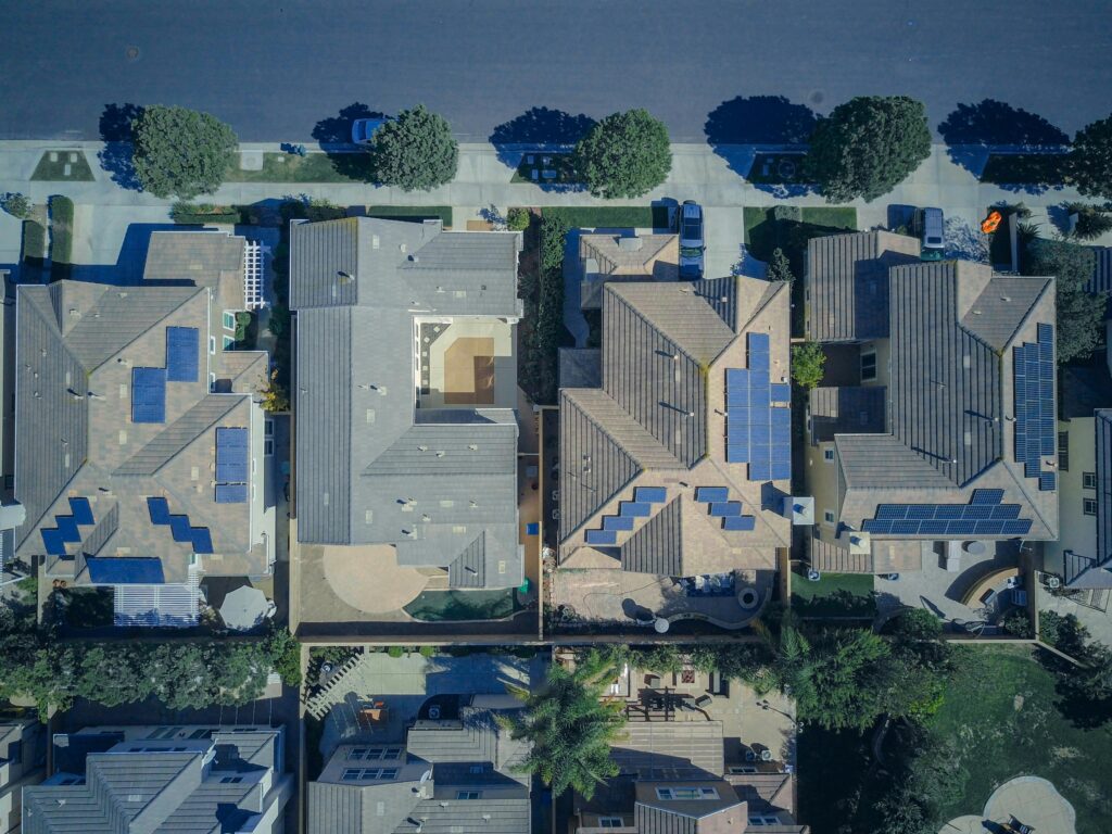 Top-down view of urban houses with solar panels emphasizing clean energy solutions.